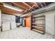 Spacious basement laundry area with shelving, utility sink, and exposed ceiling at 7382 E Bates Dr, Denver, CO 80231
