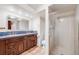 Bright bathroom features a double sink vanity, decorative tile, and glass-enclosed shower at 7382 E Bates Dr, Denver, CO 80231