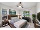 Bedroom featuring natural light from two windows, stylish decor, and an overhead ceiling fan at 7382 E Bates Dr, Denver, CO 80231
