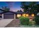 Charming single Gathering home featuring a two car garage, beautiful plants, and exterior brick work at 7382 E Bates Dr, Denver, CO 80231