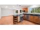 This kitchen features stainless steel appliances, an island cooktop, and natural wood cabinets at 7382 E Bates Dr, Denver, CO 80231