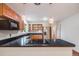 Open eat-in kitchen featuring stainless appliances, wooden cabinetry, and an island cooktop at 7382 E Bates Dr, Denver, CO 80231