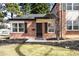 Charming brick home featuring professionally landscaped front yard and stylish black shutters at 1168 Kearney St, Denver, CO 80220