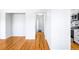 Hallway featuring freshly painted walls and refinished hardwood floors leading to bedrooms and kitchen at 1168 Kearney St, Denver, CO 80220