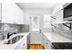 Modern kitchen featuring stainless steel appliances, white cabinetry, and stylish gray backsplash at 1168 Kearney St, Denver, CO 80220