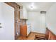 Basement utility area with exposed brick, utility sink, washer, dryer and overhead lighting at 3051 W 39Th Ave, Denver, CO 80211