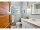 Clean bathroom with stylish vanity, modern fixtures, and glass block window at 3051 W 39Th Ave, Denver, CO 80211