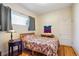 Cozy bedroom with a floral quilt, hardwood floors, and a window, providing comfort and natural light at 3051 W 39Th Ave, Denver, CO 80211
