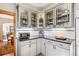 Well-lit kitchen featuring white cabinets, black countertop, and sleek glass-front cabinets at 3051 W 39Th Ave, Denver, CO 80211