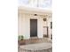 Covered front porch with decorative support columns, black front door, and a small garden at 4420 W 27Th Ave, Denver, CO 80212