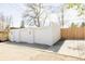 Two-car detached white brick garage with concrete driveway and light-colored wood fence under a sunny sky at 4420 W 27Th Ave, Denver, CO 80212