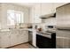 Bright kitchen with white cabinets, stainless steel appliances and a window above the sink at 4420 W 27Th Ave, Denver, CO 80212