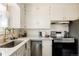 A well lit kitchen has white cabinets, countertops, and stainless steel appliances, offering a clean and modern aesthetic at 4420 W 27Th Ave, Denver, CO 80212