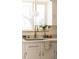 Close-up of a kitchen sink area with brass faucet, white cabinetry, and marble countertops at 4420 W 27Th Ave, Denver, CO 80212