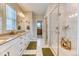 Bright bathroom with double vanity, marble floors, walk-in shower, and ample storage at 8939 Bellsong Cir, Littleton, CO 80125