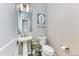 Charming powder room featuring pedestal sink, modern toilet, and stylish decor at 8939 Bellsong Cir, Littleton, CO 80125
