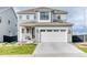 Charming two-story home featuring a gray exterior, well-maintained landscaping, and an attached two-car garage at 8939 Bellsong Cir, Littleton, CO 80125