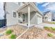 Cozy front porch with seating area, complemented by rock landscaping and a well-maintained gray exterior at 8939 Bellsong Cir, Littleton, CO 80125
