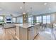 Spacious kitchen island connects to dining area and living room with fireplace and sliding glass doors at 8939 Bellsong Cir, Littleton, CO 80125