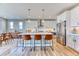 Bright kitchen with an island with barstool seating and stainless steel appliances, next to a dining area at 8939 Bellsong Cir, Littleton, CO 80125