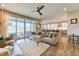 Open-concept living room featuring wood floors, a modern ceiling fan, and sliding glass doors to the outdoor space at 8939 Bellsong Cir, Littleton, CO 80125