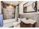 Bathroom featuring tiled walls, a tub and shower combination, and a stylish vanity with dark wood cabinets at 3109 Newport Cir, Castle Rock, CO 80104