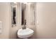 Modern half-bathroom with a pedestal sink and three decorative mirrors at 3109 Newport Cir, Castle Rock, CO 80104
