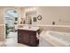 Bathroom with soaking tub and dark wood vanity adjacent to bedroom through arched doorway at 3109 Newport Cir, Castle Rock, CO 80104
