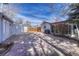 Open backyard featuring a stone patio, two storage sheds, partial fence, and overhead string lights at 6719 Quay St, Arvada, CO 80003