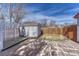 Backyard featuring a charming shed with white trim, white lattice, complemented by stone-tiled patio at 6719 Quay St, Arvada, CO 80003