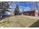 View of a large backyard featuring a well-kept lawn, brick home, and storage shed for outdoor living at 6719 Quay St, Arvada, CO 80003