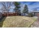 Expansive, grassy backyard offers privacy with mature trees and a wood fence; perfect for outdoor activities at 6719 Quay St, Arvada, CO 80003