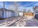 Backyard with stone patio, two storage sheds, partial fence, and overhead string lights at 6719 Quay St, Arvada, CO 80003