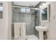 Modern bathroom featuring sleek glass-enclosed shower with gray tiling and a pedestal sink at 6719 Quay St, Arvada, CO 80003