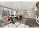 Bright dining room boasts modern chandelier, rustic table and chairs, and large sun-filled windows at 6719 Quay St, Arvada, CO 80003