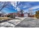 A well-kept brick home with a long driveway leading to a detached garage at 6719 Quay St, Arvada, CO 80003