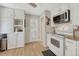 Bright kitchen features white cabinets and stainless steel appliances, with an adjacent door to the outside at 6719 Quay St, Arvada, CO 80003