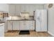 Cozy white kitchen featuring modern appliances and a stylish backsplash at 6719 Quay St, Arvada, CO 80003