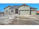 Green two-story house with stone accents and a three-car garage at 7301 E 82Nd Pl, Commerce City, CO 80022