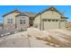 Two-story house with stone and green siding, three car garage at 7301 E 82Nd Pl, Commerce City, CO 80022