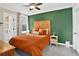 This bedroom features a unique green accent wall, a wooden headboard, and modern furnishings at 4301 Zuni St, Denver, CO 80211