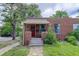Charming brick home with a well-maintained lawn and a red front door and stone walkway at 4301 Zuni St, Denver, CO 80211