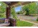 Inviting front porch featuring a swing seat, brick columns, and view of a tree-lined street at 4301 Zuni St, Denver, CO 80211