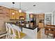 Well-lit kitchen featuring a breakfast bar, wooden cabinetry, exposed brick, and modern appliances at 4301 Zuni St, Denver, CO 80211