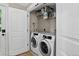 Efficient laundry room with modern washer and dryer units, plus shelving for storage at 4301 Zuni St, Denver, CO 80211