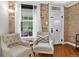Cozy living room featuring exposed brick walls, a window, and comfortable seating arrangement at 4301 Zuni St, Denver, CO 80211