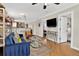Open-concept living area with exposed brick, a TV, and a smooth transition to the kitchen at 4301 Zuni St, Denver, CO 80211