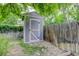 Backyard shed with an adjacent fence and manicured landscaping and a tree for shade at 4301 Zuni St, Denver, CO 80211
