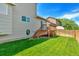 Spacious backyard featuring a wooden deck, manicured lawn, and privacy fencing at 1545 August Ln, Brighton, CO 80601