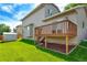 Backyard featuring a wooden deck, lush green lawn, shed, and privacy fencing at 1545 August Ln, Brighton, CO 80601